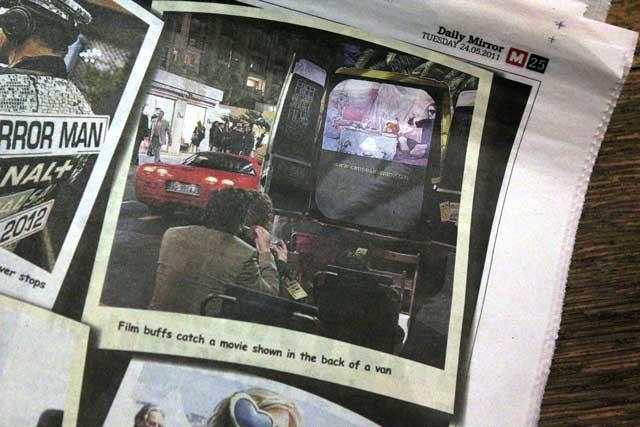 Film buffs catch a movie shown in the back of a van. 